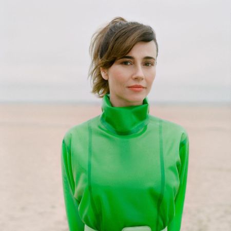 Linda Cardellini is posing in a green dress.